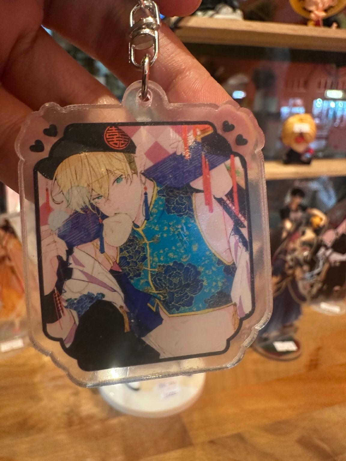 Blond anime-style character keychain in blue Chinese-inspired outfit – close-up