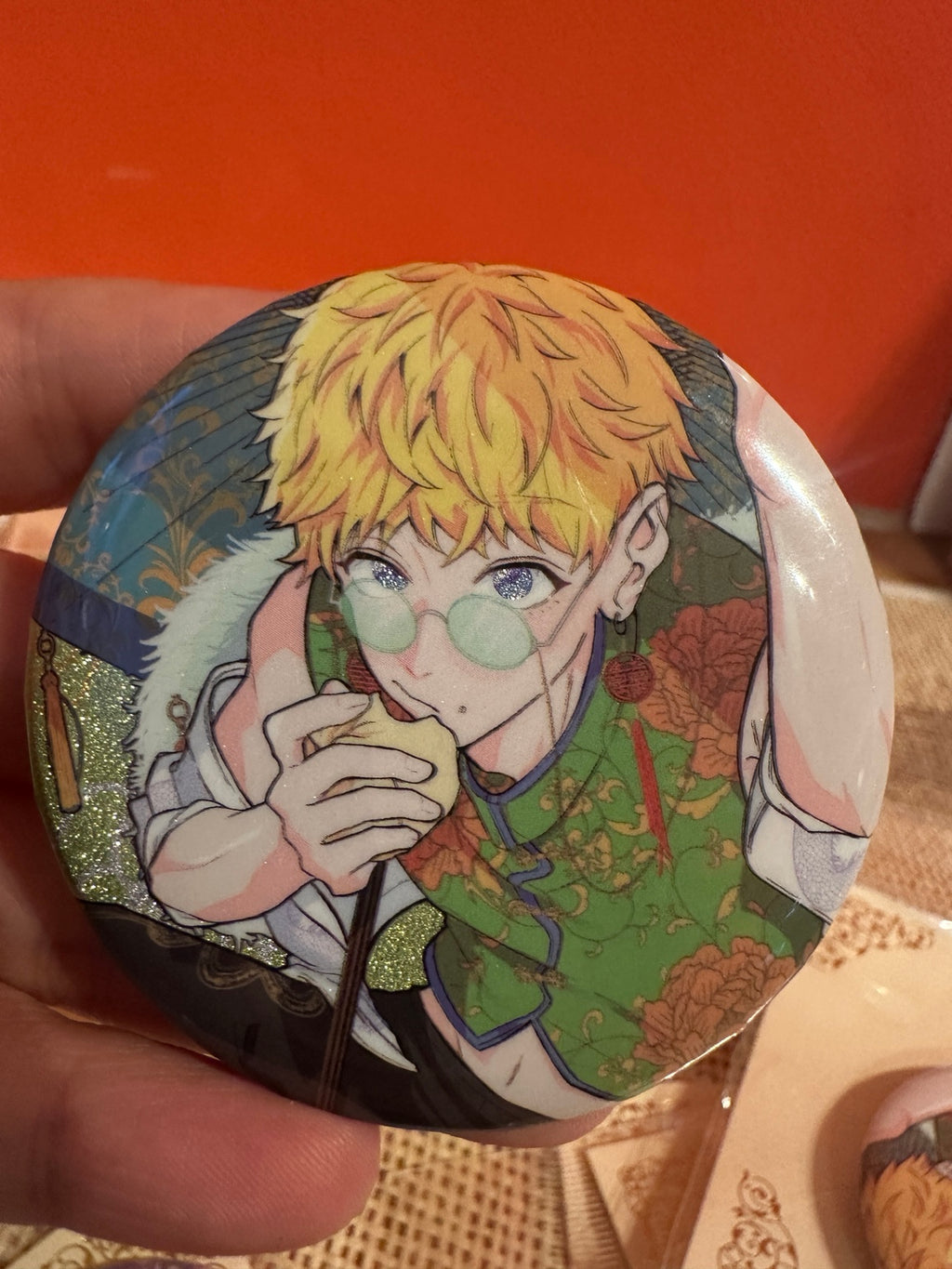 Close-up round badge with blond character wearing green glasses